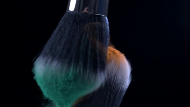 用高速相机拍摄的超级慢动作的化妆品刷子的宏观特写 画面以1000发橙色和绿色粉末在空中飞舞 — 图库视频影像