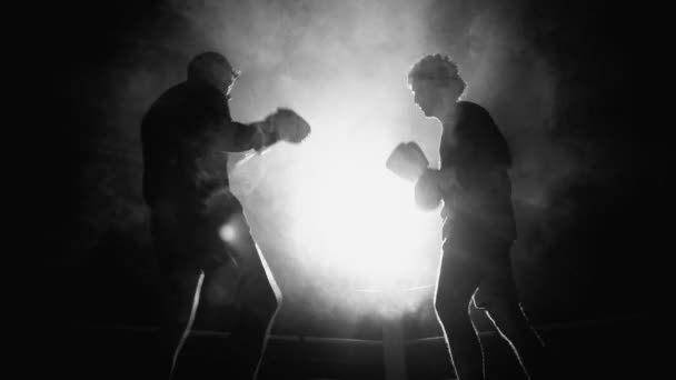 モノクロのリングの中の2つのボクサーの間の劇的な戦い バックライトが付いている黒と白 地面に相手を倒す戦闘機 — ストック動画