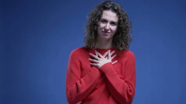 Minnettar kadın ellerini göğsüne koydu. Minnettarlığını ve inancını mavi arka planda hissetti.