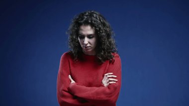 Korkmuş ve korkmuş bir şekilde kollarını kavuşturan korkunç bir kadın. Olumsuz koruyucu vücut dili, depresif ve endişeli.