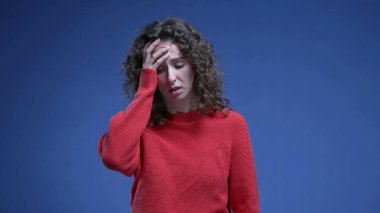 Üzüntüyle yüzünü kapatan, endişeli 20 'li yaşlarda zihinsel baskı altında ızdırap çeken bir kadın.