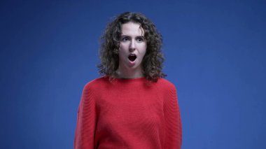 Şok ve inanmazlıkla dolu bir kadın doğrudan kameraya bakıyor. 20 'li yaşlardaki kadınlar inanılmaz haberlere şaşırarak ağızlarını kapatırlar.