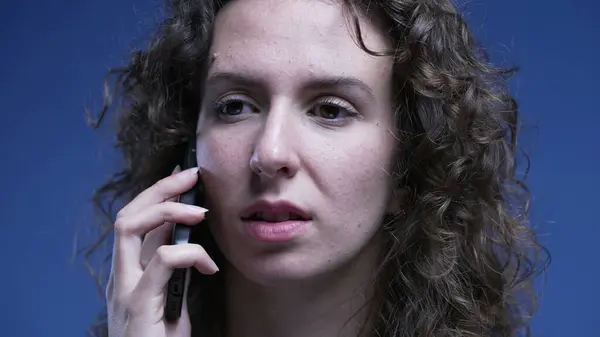 Close-up face of woman answering phone call. 20s female person pick up smartphone device and brings it to ear and starts speaking