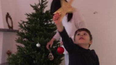 Anne ve Çocuk Noel Ağacı Dekorasyonu için Kutu Açma Süslemeleri - Gizli Aile Tatil Hazırlığı, havada yıldız tutan genç çocuk