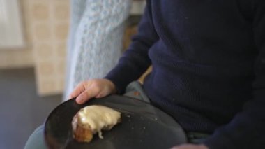 Huzursuz çocuk ekmek ve peynirli tabak tutarken kıpırdanan bacak, endişeli çocukluk konsepti, karbonhidrat yiyeceği yakın çekim