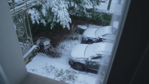 雪で覆われた車のアパート窓からの雪の日の眺め 冬の季節に住居から外を見上げる人の貧困 — ストック動画