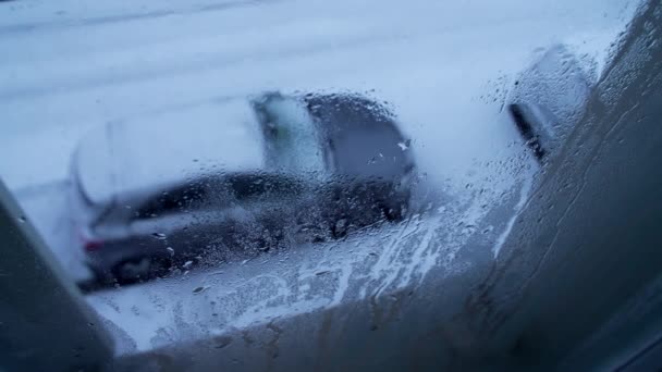 雪の日中に外を見ているアパートの窓からの眺め 人々のPovは 雪で覆われた通りや駐車された車を眺めます ホームボード — ストック動画