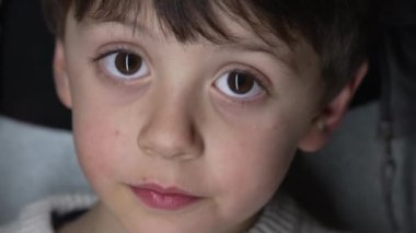 Makro mercekle çekilen kameraya bakan çocuğun yakın çekimi. Genç bir çocuğun portresi