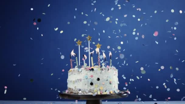 Anniversary Celebration Cake Candles Blue Background Confetti Falling Slow Motion — Stock Video