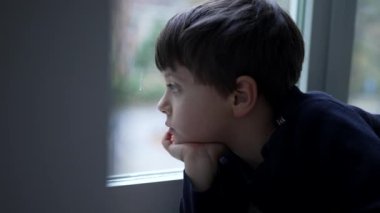 El pençe divan duran düşünceli bir çocuk. Evinin penceresinden bakıyor. Düşünceli genç bir çocuğun gerçek hayatı.