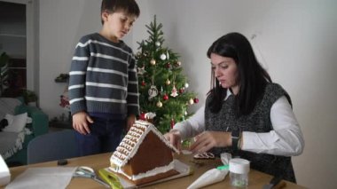 Anne ve Çocuk Zencefilli Ekmek Evi, Aralık Festivali ve arka planda Noel Ağacı. Aile tatillere hazırlanıyor