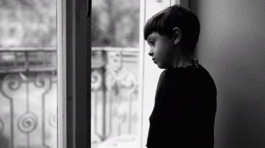 Çocukluk depresyonu, pencerenin kenarında dikilip ikinci kattaki dramatik tek renkli siyah beyaz manzaraya bakan üzgün bir çocuk tarafından resmedilmiş. Bunalımlı çocuk