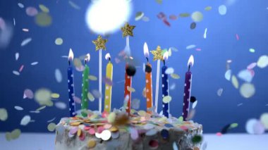 Doğum günü pastasında mumlar. Konfetiler yavaş çekimde mavi zeminde 1000 fps hızla düşüyor.