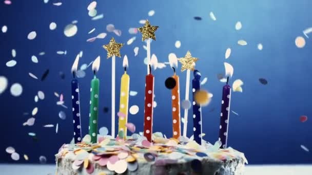 Празднование Юбилея Торта Свечами Синем Фоне Конфетти Падает Замедленной Съемке — стоковое видео