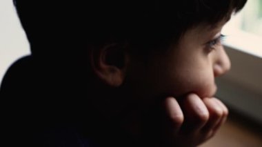 Sıkılmış küçük çocuk evde çocukluk depresyonuyla boğuşuyor. Pencereden bakarken kendini yalnız ve üzgün hissediyor.