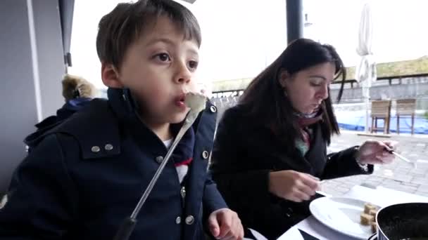 어머니와 아이는 휴가를 여행하는 레스토랑에서 스위스 퐁듀를 있습니다 치즈와 아이의 — 비디오