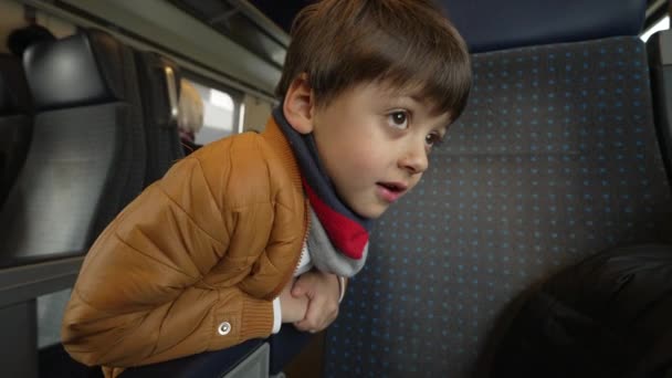 기차로 여행하는 소년이 복도에 좌석을 쳐다보며 지나갑니다 아동은 고속도로 내에서 — 비디오