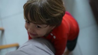 Oğul babasının bacağını tutuyor, mutlu hissediyor, ebeveynin POV 'u çocukla bağ kuruyor, çocuk gülümsüyor, sevgi dolu aile hayatı yaşıyor.