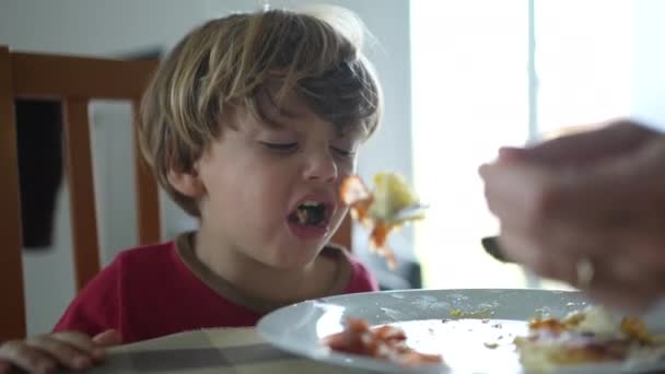 小さな男の子が昼食の時間に食べ物を吐き出しています 子供は食べ物を欲しくない 嫌悪感を感じる — ストック動画