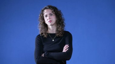 Üzgün kadın, kalça üstüne ellerini koyuyor. Endişe duyuyor ve haberlere inanmıyor. Kollarını kavuşturup olumsuz tepki veriyor.