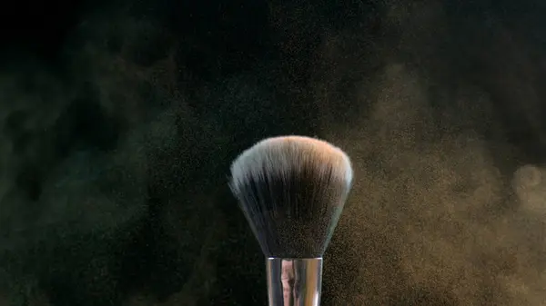 Cosmetic Brush with Orange Particle Effects captured in macro with high-speed camera