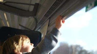 Çocuk Avrupa 'da hızlı ulaşım içinde tren perdelerini kapatıyor ve açıyor. Küçük çocuk perdeleri kapatıyor.