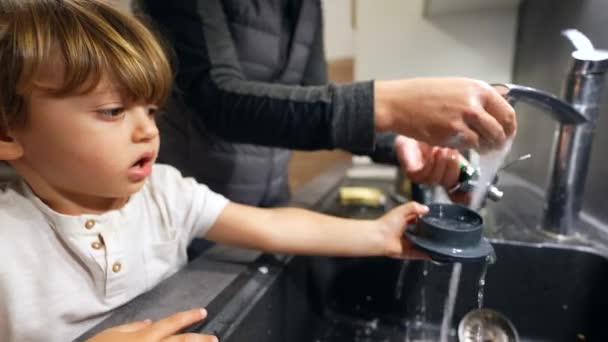 母亲和孩子用水槽洗厨房设备 用水龙头浇水 母亲和儿子负责日常事务 — 图库视频影像