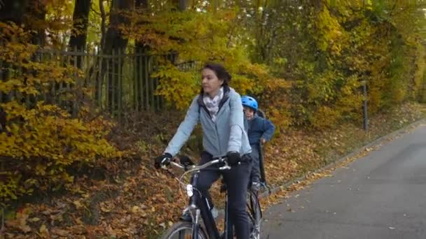 Mãe Anda Bicicleta Com Criança Banco Trás Durante Outono Dia — Vídeo de Stock