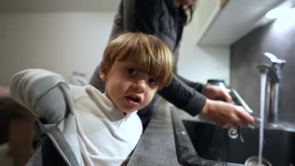 Mały Chłopiec Zdejmuje Sweter Pomaga Matce Zmywać Naczynia Zlewie Kuchennym — Wideo stockowe
