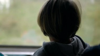 Trenle seyahat eden bir çocuğun arkası manzarayı seyreder ve cama yaslanır. Düşünceli küçük çocuk hızlı ulaşım yolculuğu sırasında hayal kuruyor.