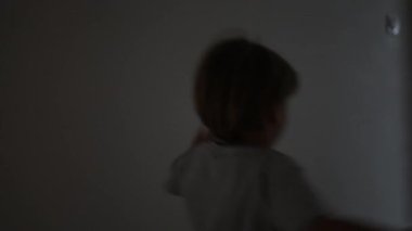Küçük bir çocuk evin içinde koşuyor ve evdeki kanepeye dalıyor. Çocuk evde koşuyor ve kanepeye atlıyor.