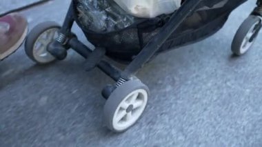 Hareket halindeki bebek arabasının yaklaşması - asfalt kaldırımda bebek arabasını itmek