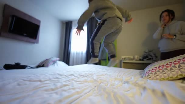 Carefree Little Boy Saltando Cama Del Hotel Alegría Vacaciones Familia — Vídeos de Stock