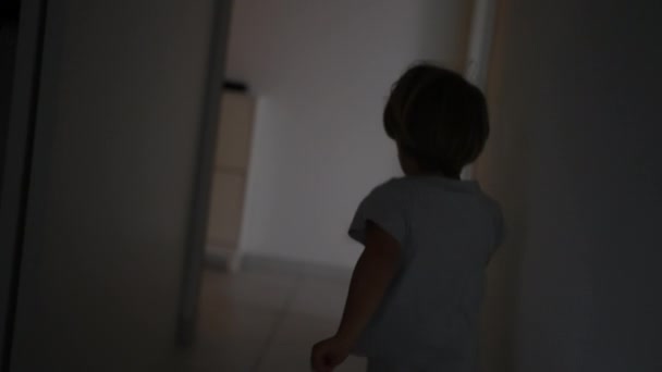 家の廊下で走っている小さな男の子の背中 屋内アパートでスプリント子供のシルエットの影 — ストック動画