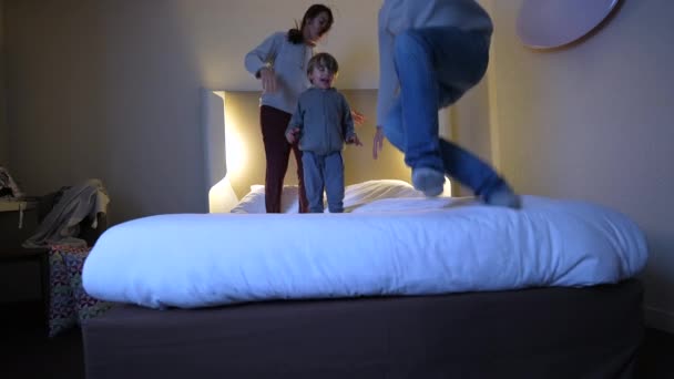 Ευτυχισμένοι Ανέμελοι Γονείς Που Πέφτουν Στο Κρεβάτι Τον Τρίχρονο Γιο — Αρχείο Βίντεο