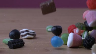 Variety of candy assortments falling down in super slow-motion at 1000 fps captured with a high-speed camera. Colorful diverse industrial sweets
