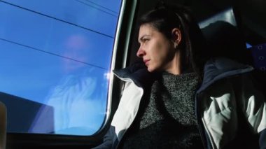 Woman squinting eyes reacting to sun rays hitting face while traveling by train. passenger closes eyes to protect from sun