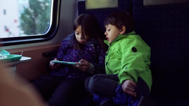 Passenger Small Girl Playing Game Handheld Console While Younger Brother — Stockvideo