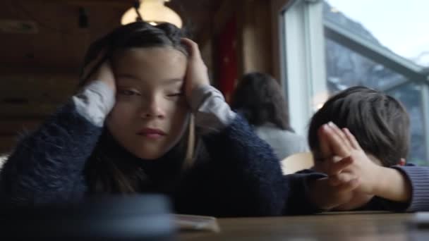 Gelangweilte Kinder Restaurant Jüngerer Bruder Gibt Vor Mit Händen Auf — Stockvideo