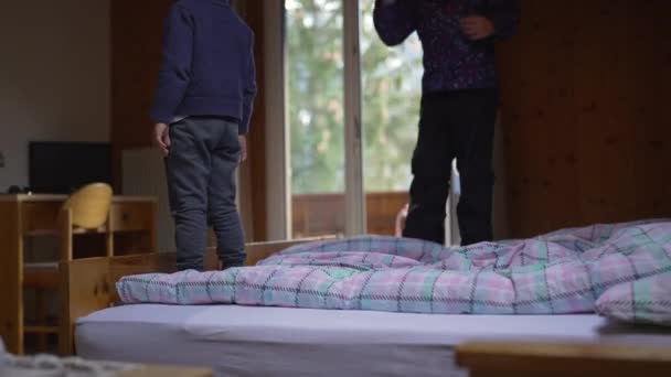 Kleiner Junge Fällt Ins Bett Schwester Hüpft Hintergrund Holzchalet Den — Stockvideo