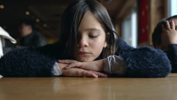 テーブルの上の頭を持つ抑圧された子供は 深い悲しみを感じます テーブルの上に頭を下げたメラノキストリック8歳の子供 — ストック動画