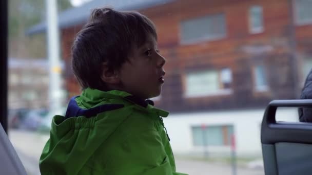 Ένα Μικρό Αγόρι Κάθεται Από Παράθυρο Του Λεωφορείου Φορώντας Πράσινο — Αρχείο Βίντεο