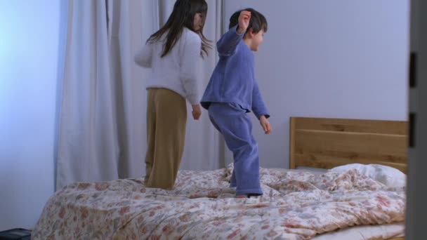 Ευτυχισμένο Κοριτσάκι Πηδάει Στο Κρεβάτι Αργή Κίνηση Αδέρφια Πηδούν Πιτζάμες — Αρχείο Βίντεο