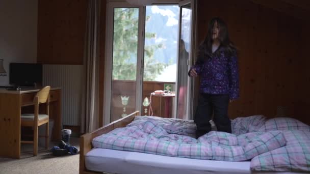 Энергичный Ребенок Прыгает Вверх Вниз Постели Время Семейного Отдыха Швейцарских — стоковое видео