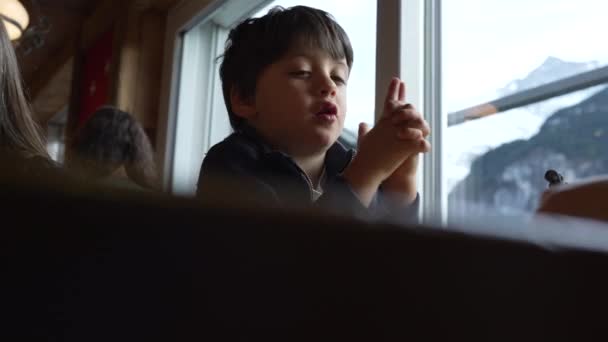 小男孩一边等待食物到达餐馆 一边假装用手射击手枪 不安的男婴 — 图库视频影像