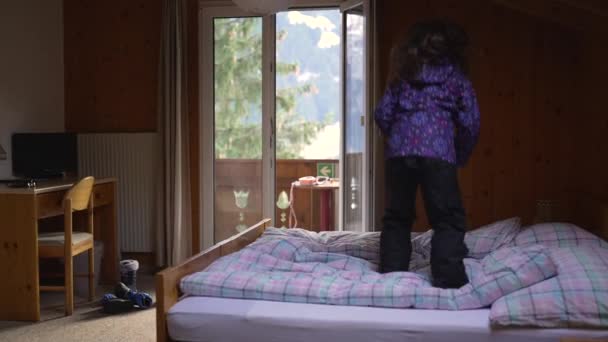 Ένα Χαρούμενο Μικρό Κορίτσι Αναπηδά Στο Κρεβάτι Μέσα Ελβετικό Ξύλινο — Αρχείο Βίντεο