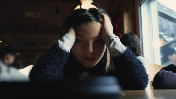 疲れた退屈な少女は レストランのディナーで手で顔を覆い 悲しい子供は疲れを感じ 退屈を感じます — ストック動画