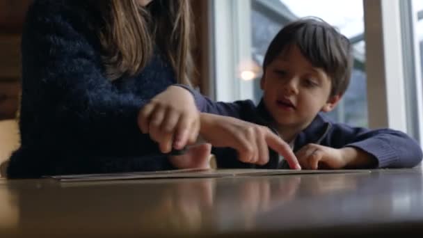 小兄弟们在餐厅里决定吃什么 孩子的手放在菜单上 — 图库视频影像