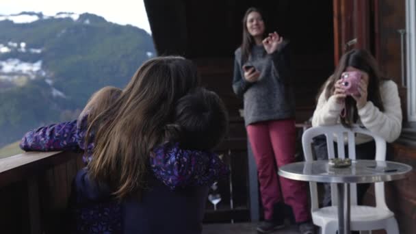 在冬季滑雪季节 孩子们摆出姿势在Chalet阳台拍照 妈妈用偏振镜给孩子们拍照 — 图库视频影像