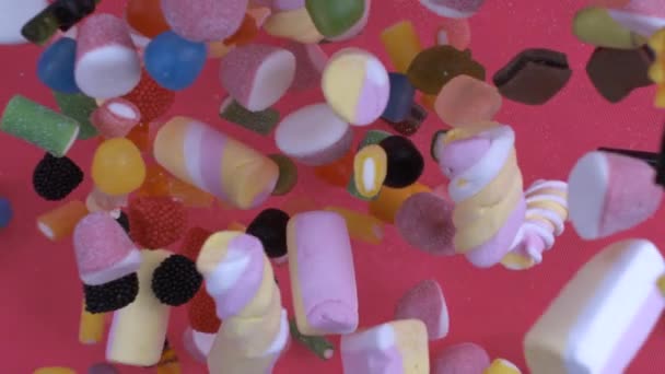 スーパースローモーションで落ちる多くのキャンディー さまざまな砂糖のトリート — ストック動画